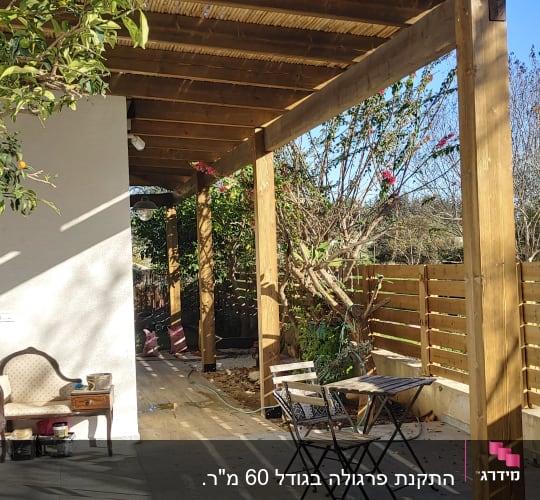 פרגולה מעץ עם שולחן וכיסאות בגינה